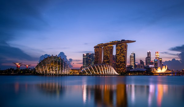Обои на рабочий стол: architecture, blue sky, clouds, evening, Gardens By the Bay, lights, reflection, Singapore, skyscrapers, sunset, архитектура, вечер, город-государство, закат, залив, мегаполис, небоскребы, облака, огни, отражение, подсветка, сингапур, синее небо