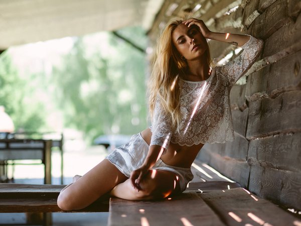 belly, blonde, bokeh, dark eyes, depth of field, Ernest K. Madej, girl, hand in hair, hips, legs, lips, looking at camera, looking at viewer, model, mouth, navel, photo, photographer, portrait, shorts, sitting, tattoo, top, tummy, wavy hair, white top