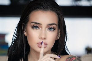 Обои на рабочий стол: bare shoulders, blue eyes, brunette, close up, depth of field, face, finger on lips, girl, lips, long hair, looking at camera, looking at viewer, model, mouth, photo, portrait, straight hair, tattoo