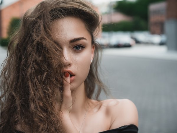 bare shoulders, blue eyes, bokeh, brown hair, brunette, close up, depth of field, Elizabeth Pankratova, face, finger on lips, girl, hair in face, Ilya Pistoletov, lips, lipstick, long hair, looking at camera, looking at viewer, model, mouth, open mouth, photo, photographer, portrait, street, urban, wavy hair