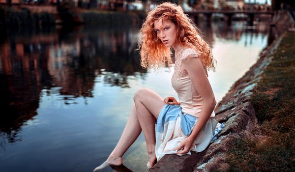 Обои на рабочий стол: bare legs, bare shoulders, barefoot, blue eyes, Cloé, curly hair, depth of field, dress, face, feet, freckles, girl, legs, lips, Lods Franck, long hair, looking at camera, looking at viewer, model, mouth, photo, photographer, portrait, redhead, river, Riverside, shirt, sitting, skirt, water