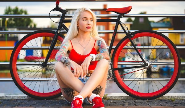Обои на рабочий стол: bicycle, blonde, blue eyes, fence, girl, jean shorts, legs, legs crossed, lips, looking away, model, mouth, necklace, photo, portrait, red top, short shorts, shorts, sneakers, socks, tank top, tattoo