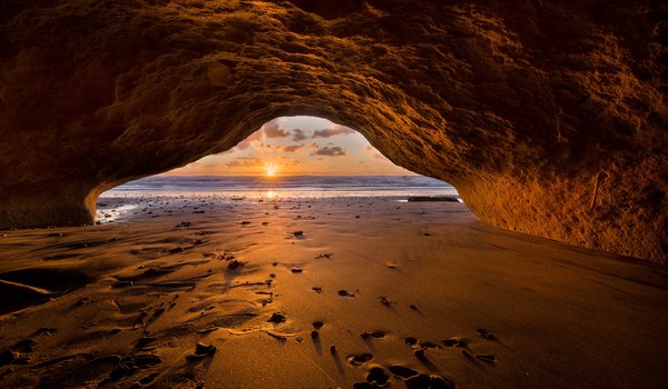 Обои на рабочий стол: beach, cave, clouds, horizon, landscape, nature, ocean, sand, sky, sun, sun rays, sunset, view from the cave, view from the cave cave, вид из пещеры, горизонт, закат, небо, облака, океан, пейзаж, песок, пещера, пляж, природа, солнечные лучи, солнце