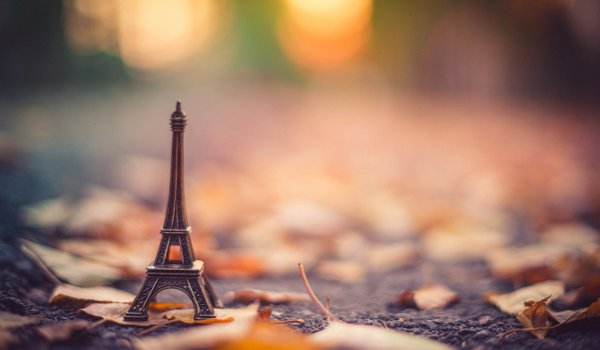 Обои на рабочий стол: La tour Eiffel, асфальт, боке, листья, осень, подставка, размытость, статуэтка, сухие, эйфелева башня