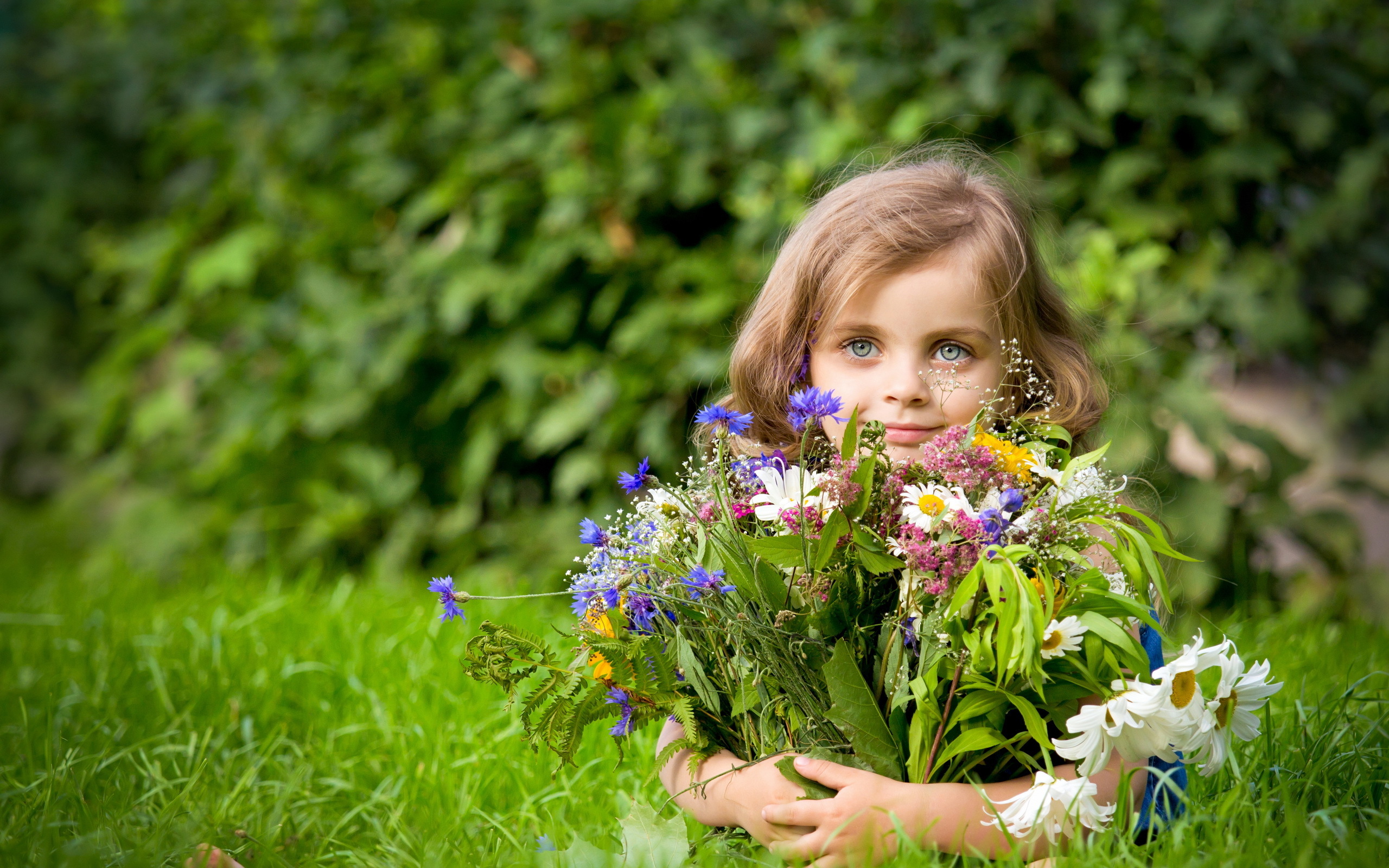 Девочка с цветами в траве загрузить
